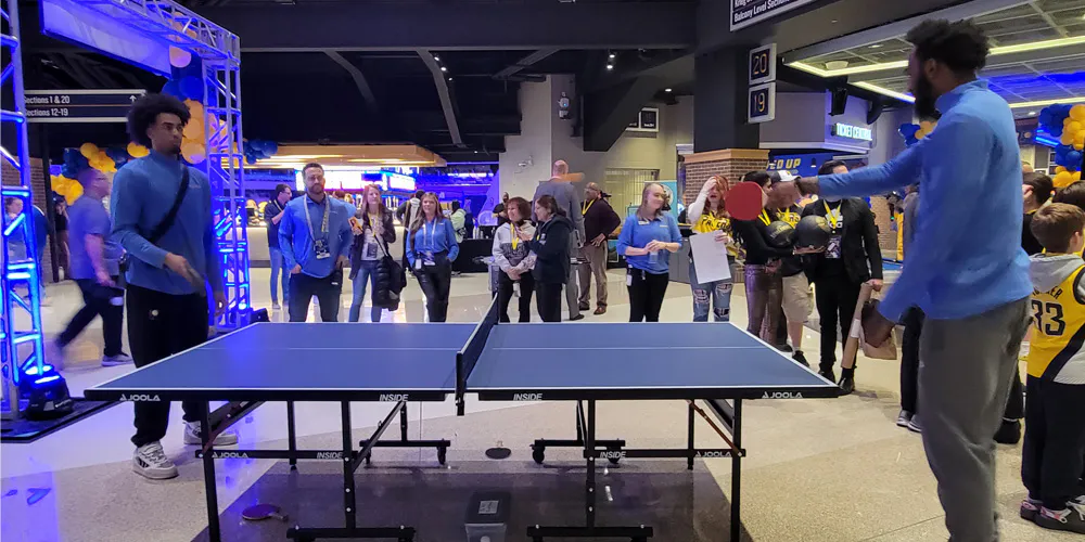 A promotional event activation on an arena concourse with games and guests